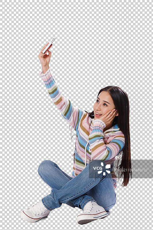 青春活力的年轻女孩用手机拍照图片素材