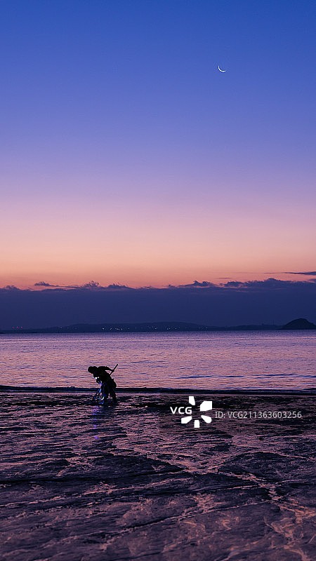 挖蛤人     2022.1.1日出前厦门环岛路沙滩上挖蛤的人图片素材
