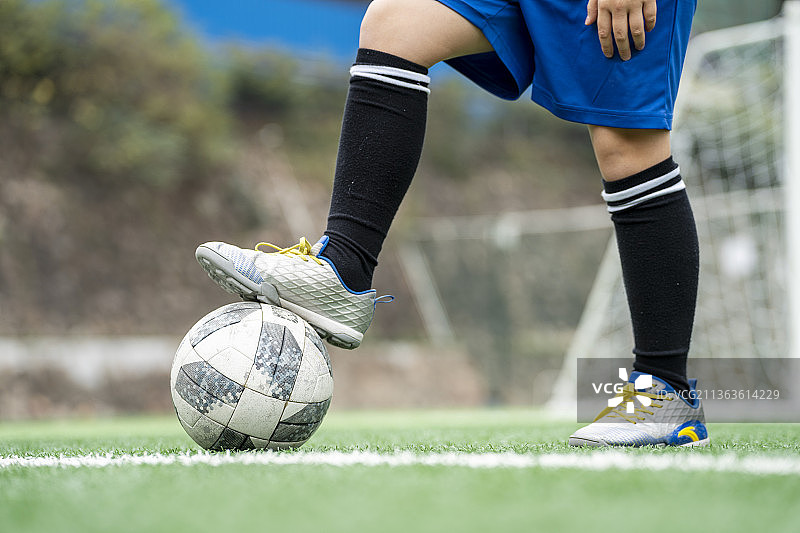 足球场上运动员单脚踩着足球图片素材
