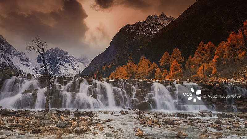 2017年11月2日秋天的川西远山白雪皑皑，眼前溪流飞瀑，艳丽的彩林杂陈期间，醉了山水，醉了游人。图片素材