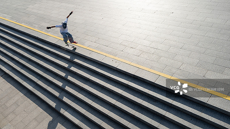 一名少年正在空地上进行滑板运动图片素材