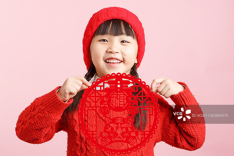 手拿虎年剪纸的中国小女孩图片素材