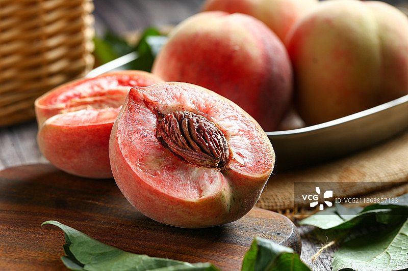 新鲜桃子掰开放在木板上图片素材