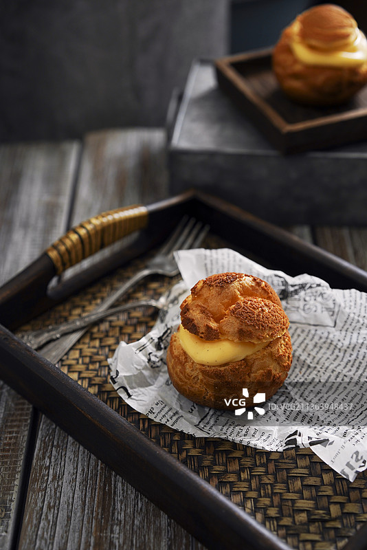 暗调木质托盘里的泡芙图片素材