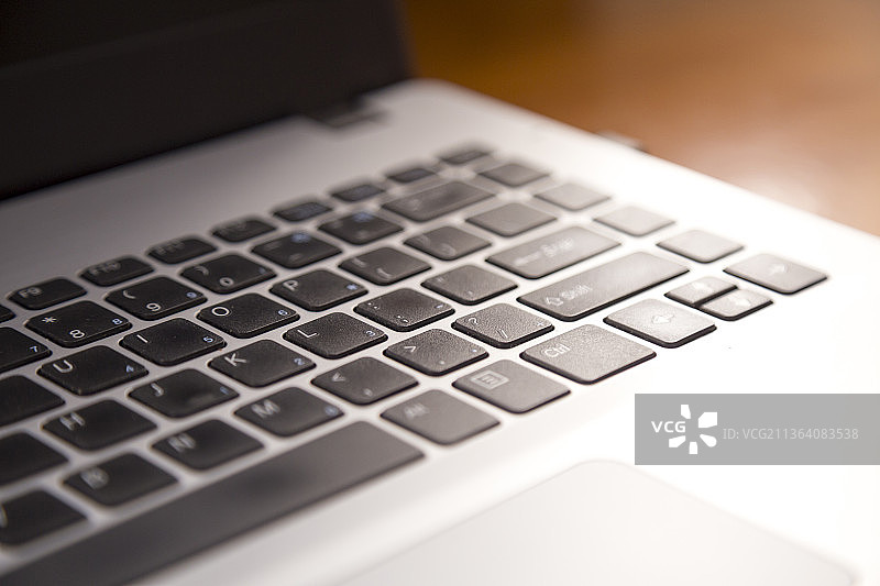 侧逆光的笔记本电脑局部特写图片素材