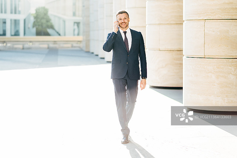 穿着正式服装的成功男商人正在打电话图片素材