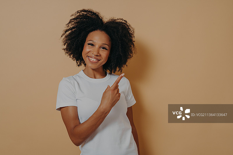 穿着白色衬衫的女人用食指指着空白的复制空间图片素材