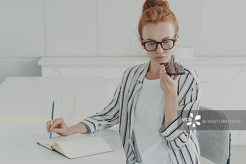 女人在智能手机上使用语音识别系统图片素材