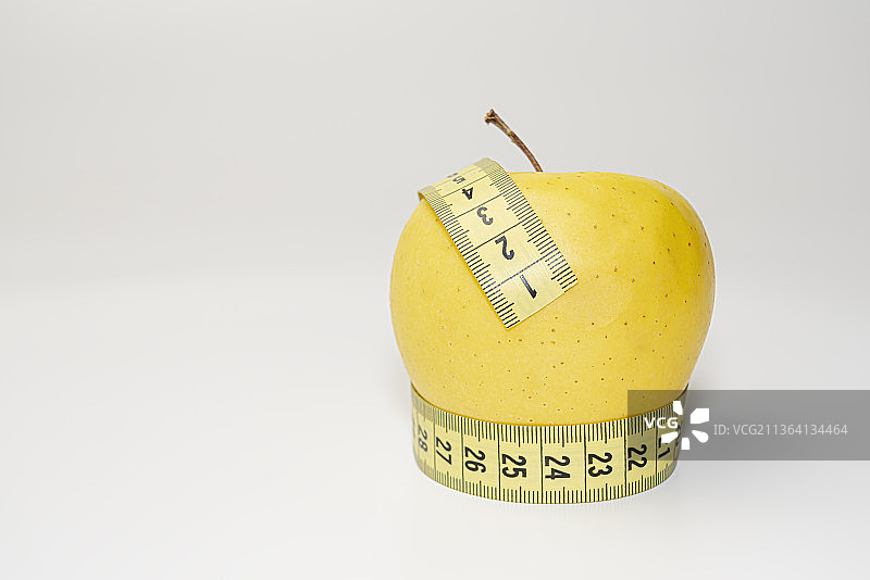 白色背景上的黄色苹果减肥丝带图片素材