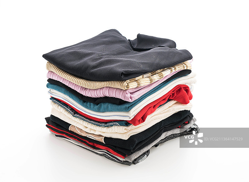 白色背景上的成堆衣物，白色背景上的堆叠书籍特写图片素材