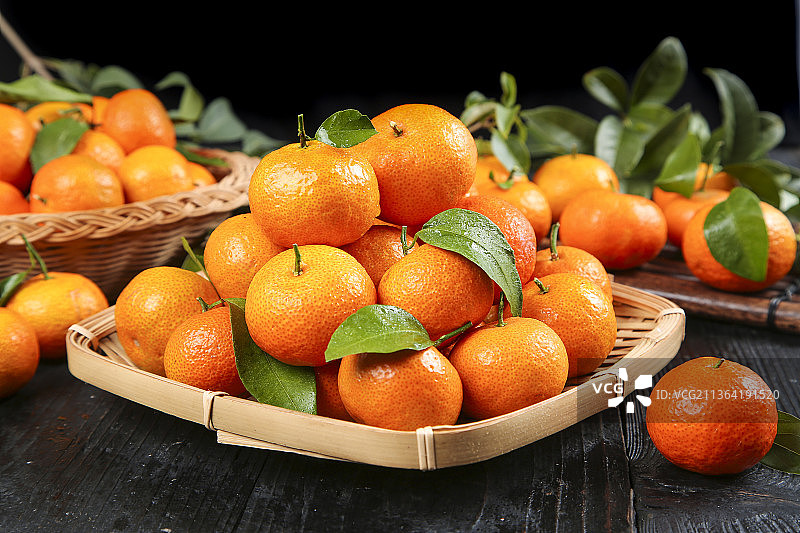 黑石板上放着一筐广西砂糖橘图片素材