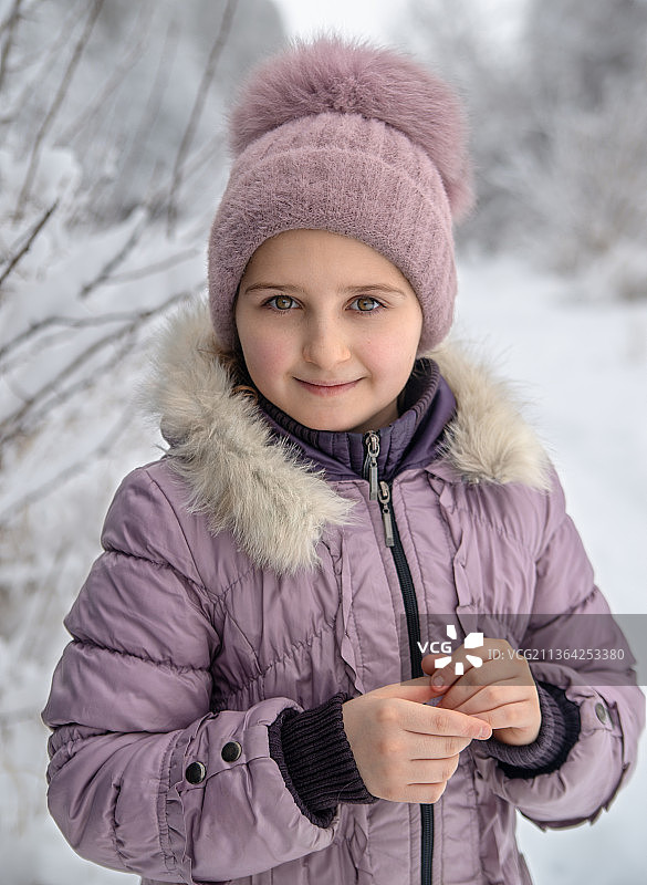 站在乌克兰雪地上的微笑女孩肖像图片素材