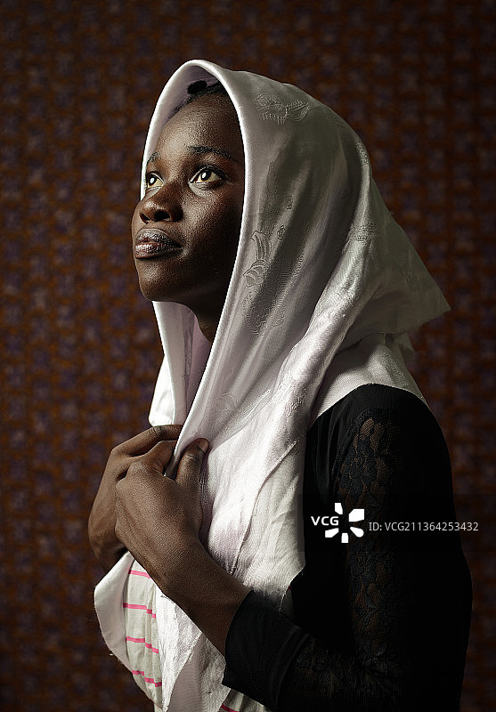戴着头巾靠墙的女人图片素材