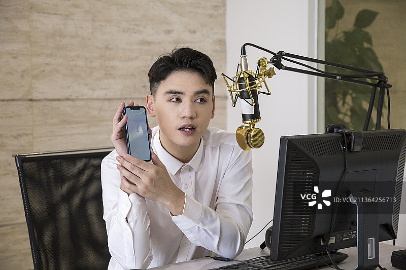 东方男性网络主播在直播间介绍商品图片素材