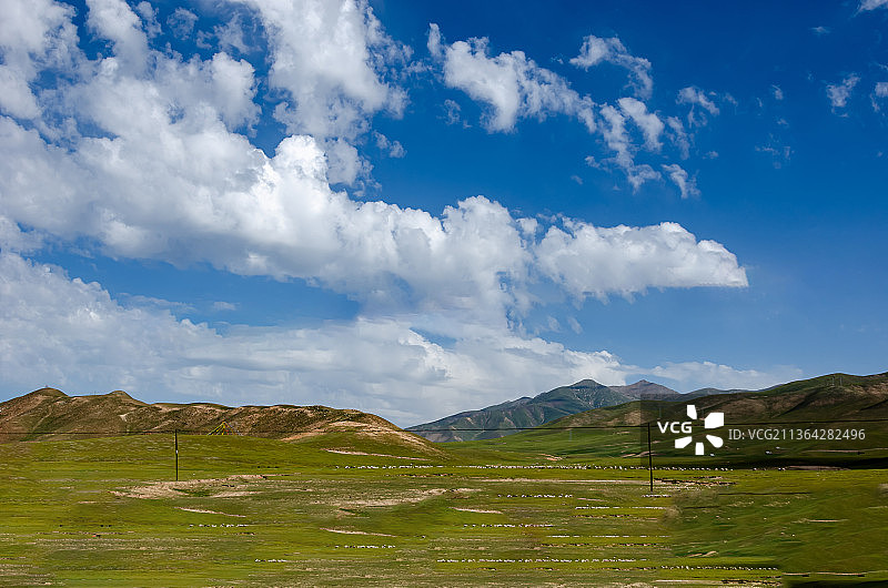 夏季晴朗天气蓝天白云的中国青海海北海晏县金银滩草原的草和山脉图片素材