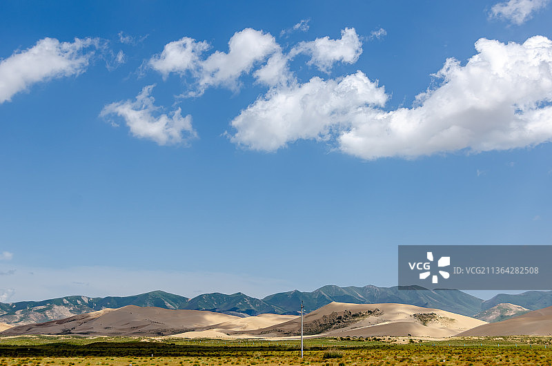 夏季晴朗天气蓝天白云的中国青海海北海晏县金银滩草原的草和山脉图片素材