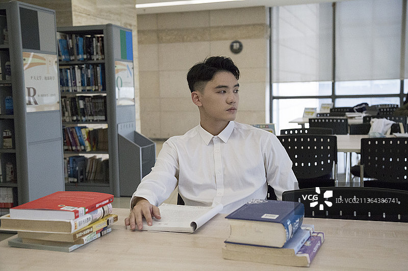一个东方男人在图书馆看书图片素材
