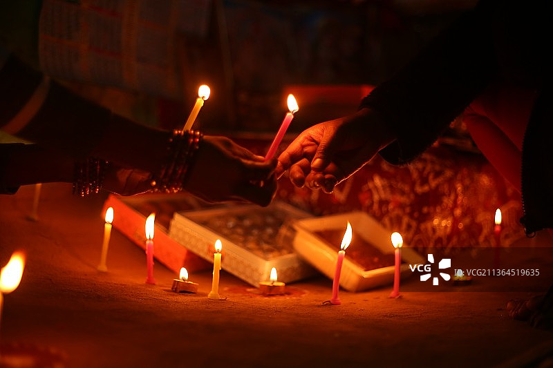 人们在寺庙里手持点燃的蜡烛的裁剪图图片素材