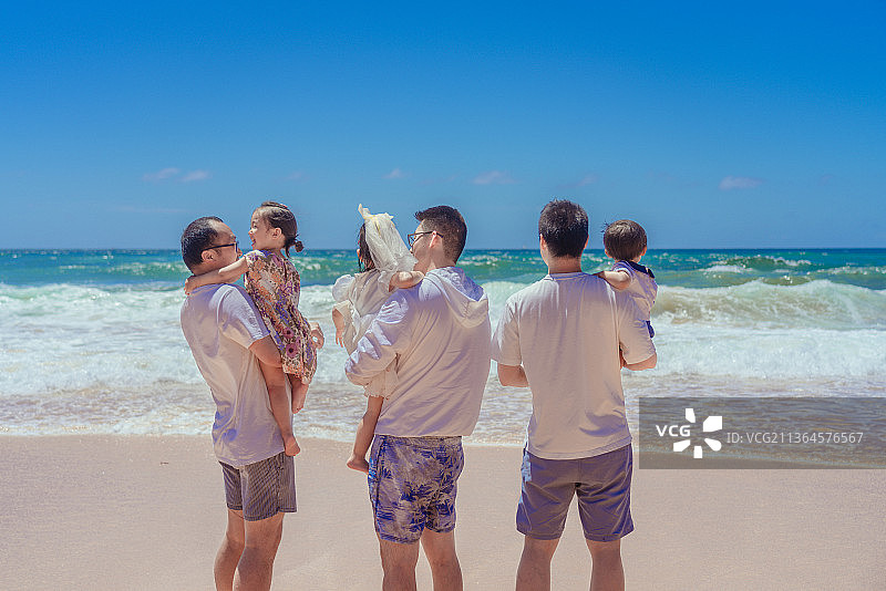 海边爸爸们抱着孩子看海图片素材