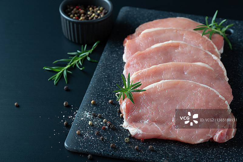 黑色背景下的生猪肉片，顶部视角，留有文本空间图片素材