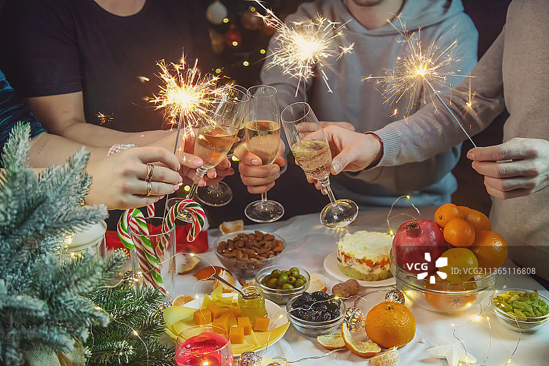 圣诞树背景下手持香槟的人们图片素材