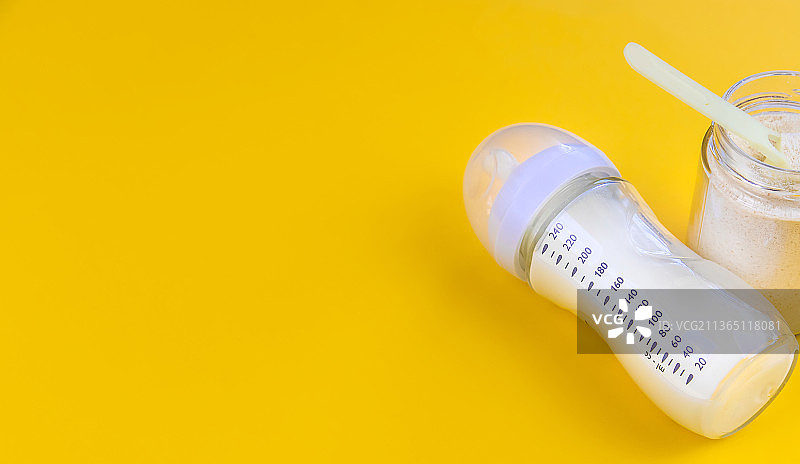 黄色背景上的婴儿奶及配件选择性聚焦图片素材