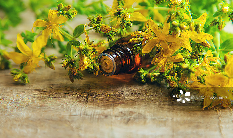 小瓶中的圣约翰草精油，选择性聚焦图片素材
