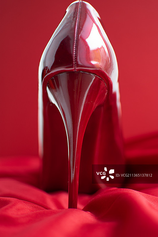 红色鞋子在红色织物上的情人节贺卡特写图片素材