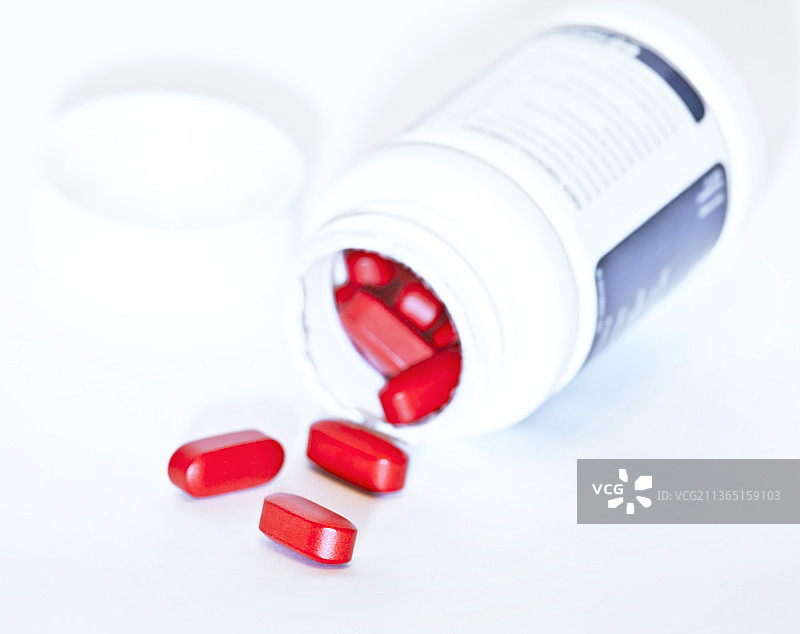 白色背景上瓶子溢出的药丸特写图片素材