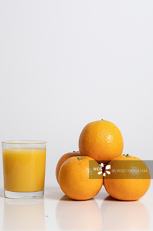 白色背景下的橙汁和橙子特写图片素材