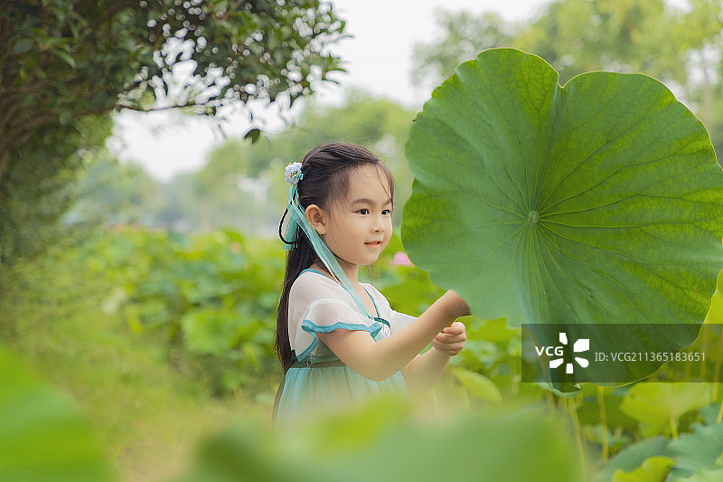荷塘边手拿荷叶穿汉服的小女孩图片素材