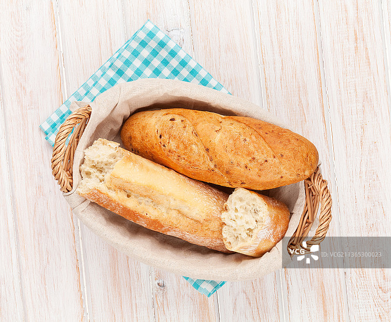 篮子里的新鲜法棍面包，桌子上的面包高角度视图图片素材