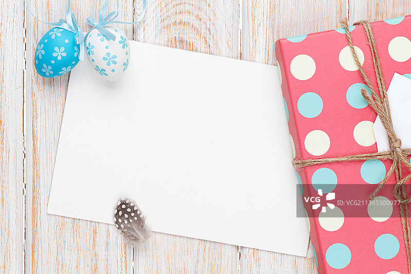 复活节贺卡，白色木板上的彩蛋和礼品盒图片素材