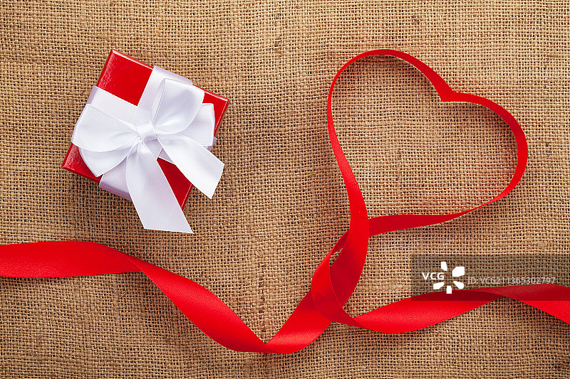 麻布情人节背景上的心形丝带礼盒图片素材