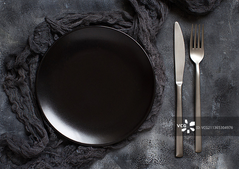 深色背景上的黑色餐盘俯视图图片素材