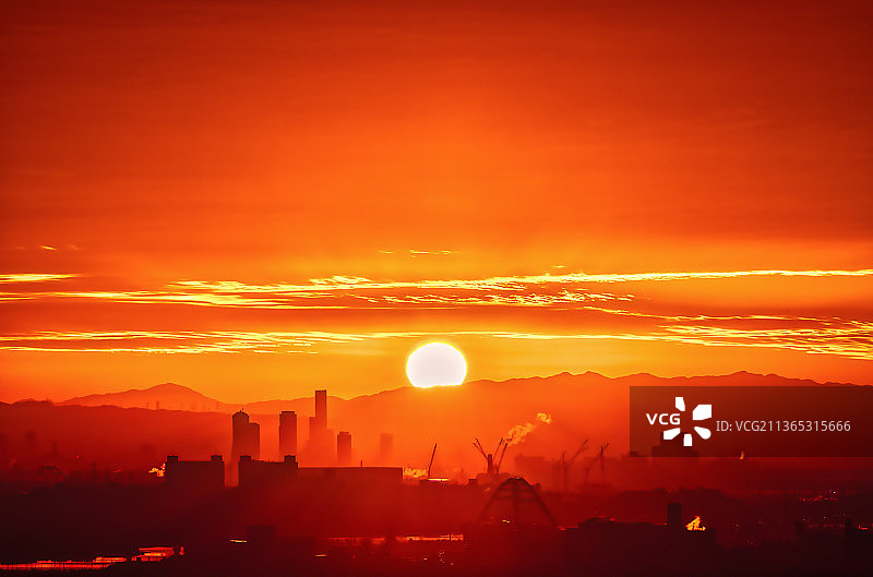 大阪的日出：日落时分建筑物在天空中的剪影图片素材