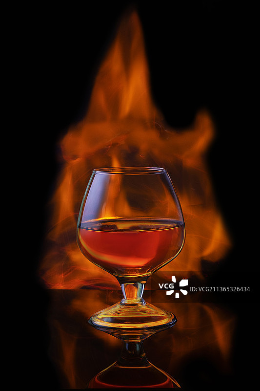 黑色背景上带冰块的燃烧酒精饮品图片素材