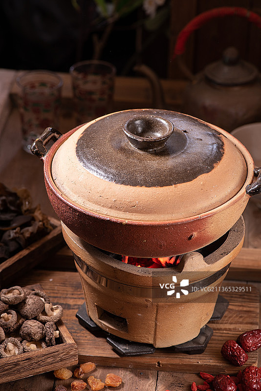 炭炉上正在熬煮食物的砂锅图片素材