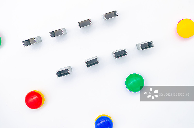 中国室内影棚拍摄静物办公文具，竖立的一排订书机和一堆圆形磁吸贴图片素材