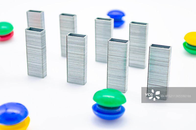 中国室内影棚拍摄静物办公文具，竖立的一排订书机和一堆圆形磁吸贴图片素材