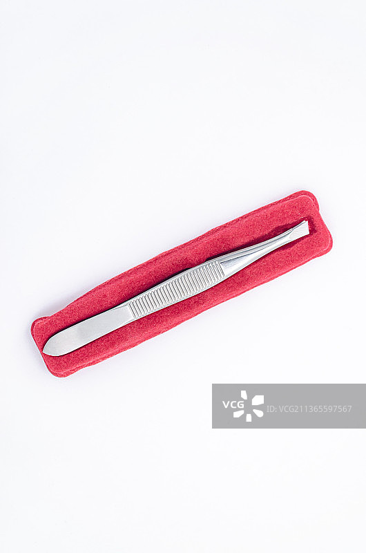 亚洲中国内室内影棚拍摄静物，装在红色包装盒里的镊子图片素材