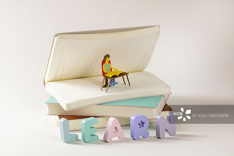 在书本上学习的手工小纸片人图片素材