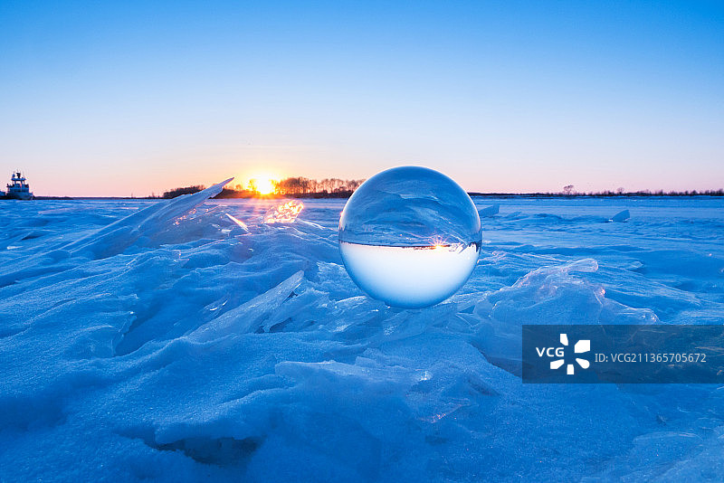 冬天日落时分冰河上的水晶球图片素材