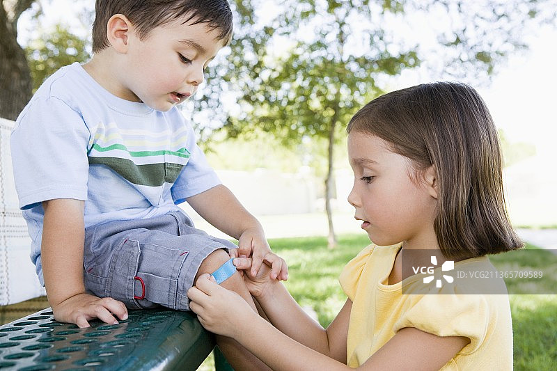 姐姐给弟弟的膝盖贴创可贴图片素材