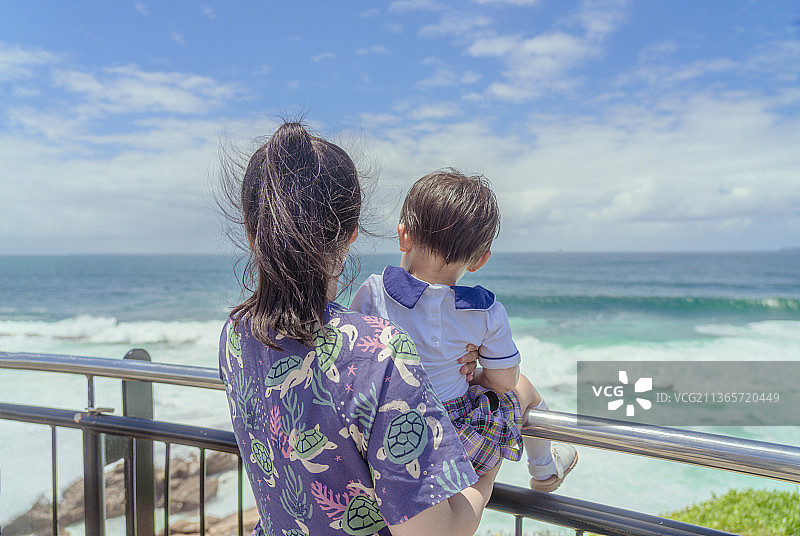 悬崖步道观赏大海风光的时尚母亲小男孩图片素材