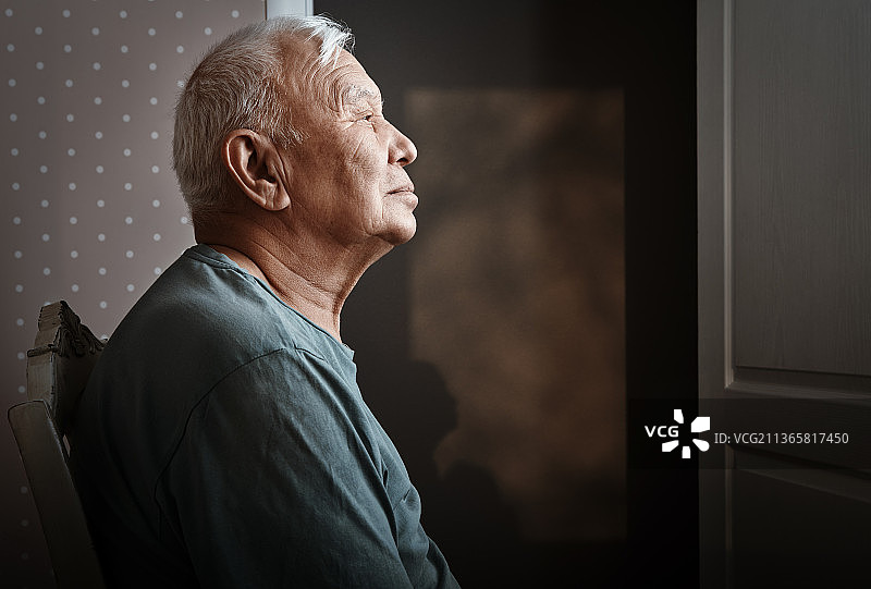 在家中坐在椅子上沉思的老年男子图片素材