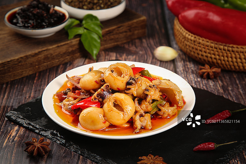 黑石板上放着一盘麻辣墨鱼仔图片素材