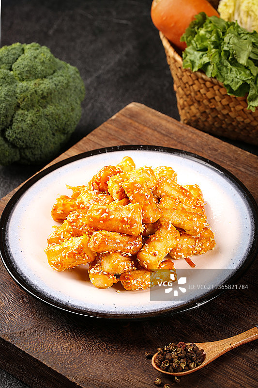 木底上摆放着一盘拔丝山药图片素材