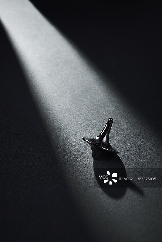 灰色背景上的旋转陀螺与阴影图片素材