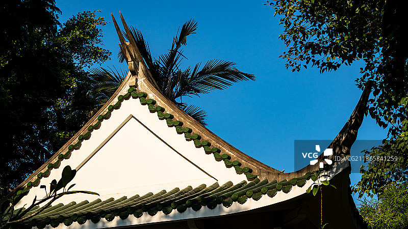 绿树掩映下的三角形屋顶和翘椽。图片素材